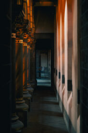 Verlichte zijgang met historische zuilen in de Gratiekerk in Antwerpen.