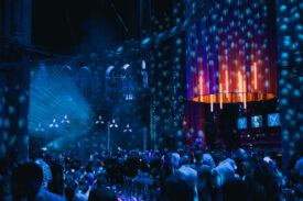 Gasten verzamelen in de verlichte Gratiekerk tijdens het avondfeest van Grundfos.